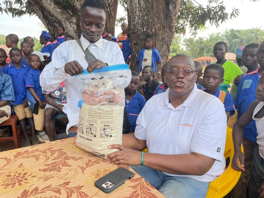 A community member of Kamawornie village presenting gift to Sylvester