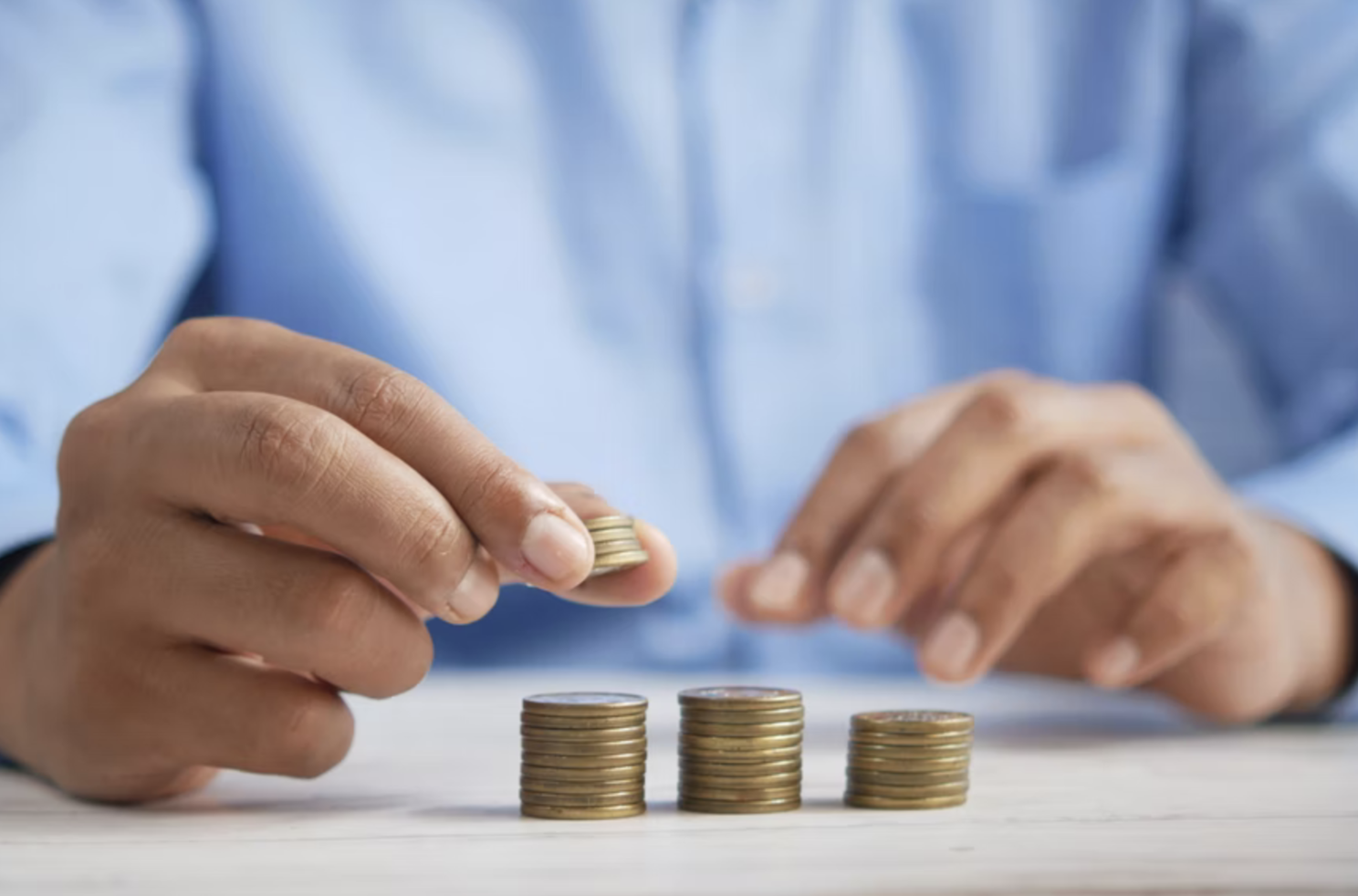a man stacking up golden coins in three columns