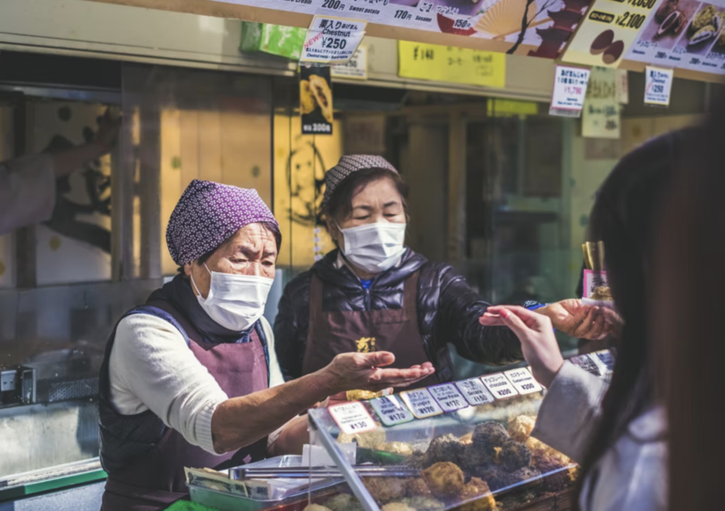 groceries seller in local market wearing nose masks selling their oods